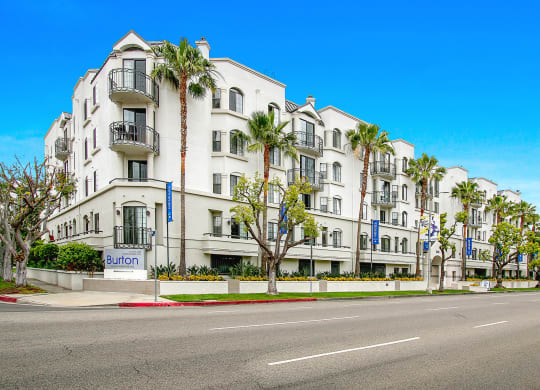 a white building with palm trees in front of a street at Burton, Los Angeles, California
