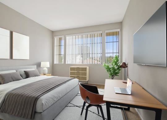 a bedroom with a bed and a desk with a laptop at Darlington Apartments, Los Angeles, California