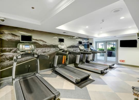 a gym with treadmills and televisions  at Apex Mission Valley, San Diego, California