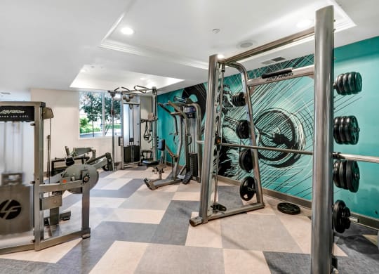 a home gym with a turquoise wall and a checkered floor  at Apex Mission Valley, San Diego, California