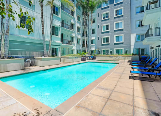 an apartment with a swimming pool in front of a building   at Apex Mission Valley, San Diego, California