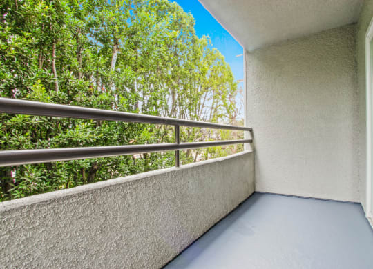 a balcony with a view of trees and a blue sky at Palm Royale Apartments, California, 90034