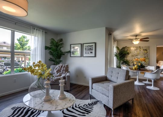 a living room with a table and chairs and a large window at Bella Terra Apartments, Henderson, Nevada