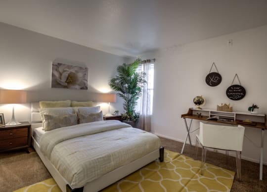 a bedroom with a bed and a desk at Bella Terra Apartments, Henderson