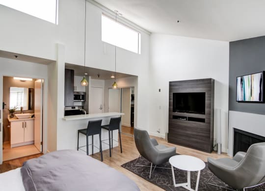 a bedroom with a bed and a chair in a room  at El Greco Lofts, Los Angeles, CA