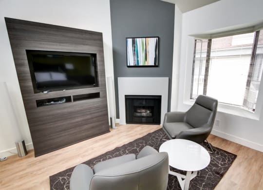 a living room with a fireplace and two chairs  at El Greco Lofts, Los Angeles, 90024