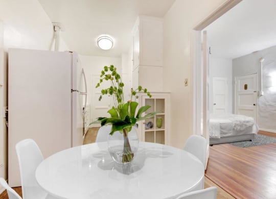 a white table with a vase of flowers on top of it at 1022 Tiverton, Los Angeles, CA