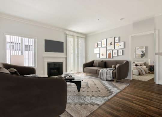 A living room with a brown couch, a fireplace, and a TV on the wall.
