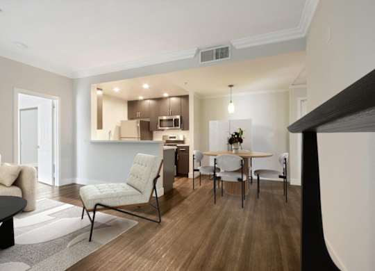 A modern living room with a dining area and a kitchen in the background.