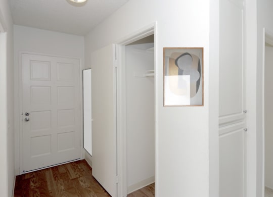 a bedroom with a white door and a painting on the wall