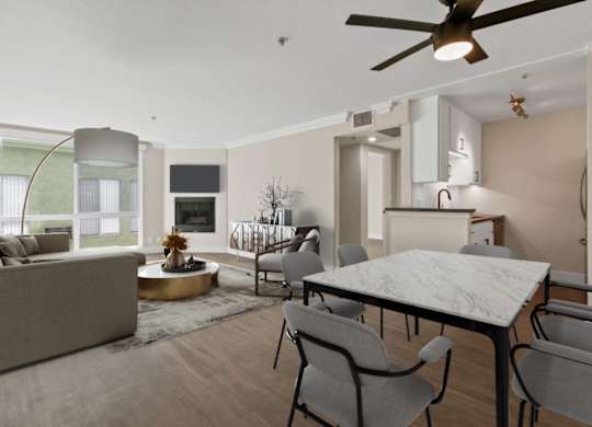 A modern living room with a grey sofa, a round coffee table, and a dining table with chairs at Rochester Apartments, California, 90024