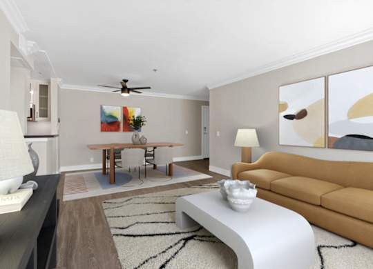 A living room with a brown couch, a white coffee table, and a painting on the wall at Rochester Apartments, California, 90024