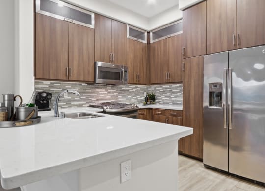 a kitchen with stainless steel appliances and a white counter top at The Adler Apartments, California, 90025