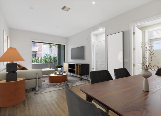 a living room with a table and chairs and a television at The Adler Apartments, Los Angeles, CA