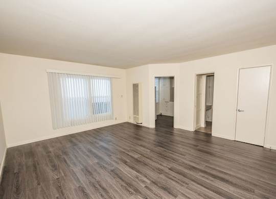 A room with vinyl flooring and white walls.