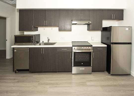 Sample Unit: Kitchen and Appliances including refrigerator, microwave, stove, and cabinets