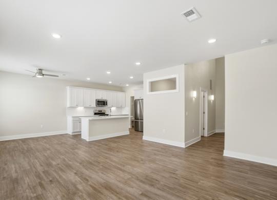 A spacious kitchen with a white countertop and a microwave.