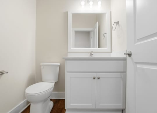 A white toilet sits next to a white cabinet in a bathroom.
