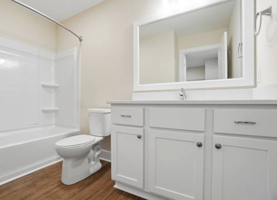 A white toilet sits in a bathroom next to a white cabinet.