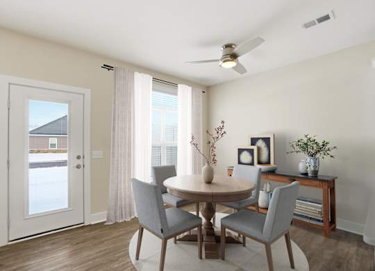 A dining room with a table and chairs.