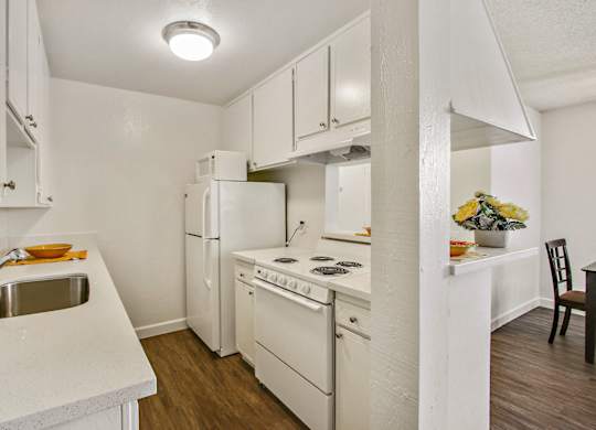 Kitchen with refrigerator, microwave, electric range, white quartz countertops, white kitchen cabinets
