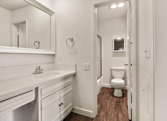 Single vanity area with white quartz countertops, white cabinets bathroom on the right