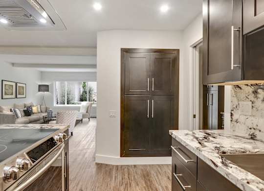 Kitchen with Stainless steel electric range, pantry, wood style floors, dark brown kitchen cabinets