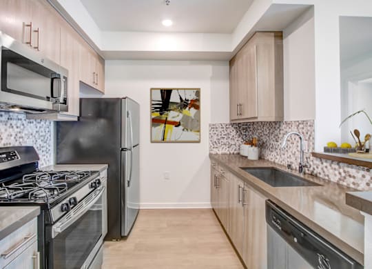 A kitchen with a black stove top oven and a black refrigerator.at Vues on Gordon, Los Angeles, 90028 