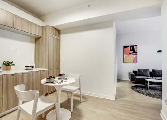 A dining area with a white table and chairs.at Wilshire Margot, Los Angeles, CA 