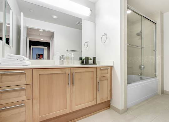 A bathroom with a vanity and a walk-in shower.at Wilshire Margot, Los Angeles 