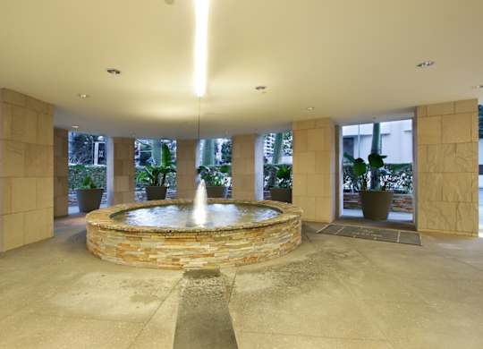 A fountain in the middle of a courtyard surrounded by stone walls.at Wilshire Margot, Los Angeles, CA 90024