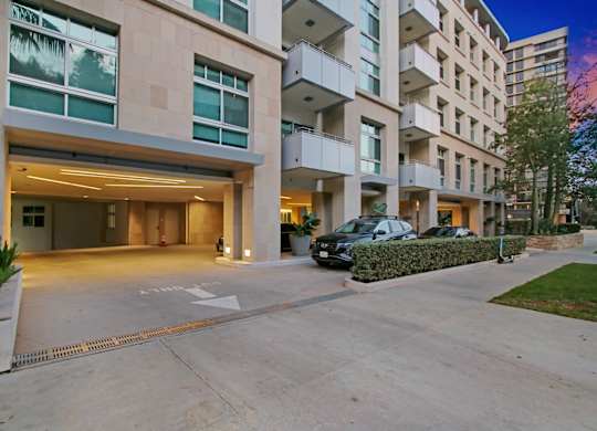 A modern building with a parking area in front.at Wilshire Margot, California