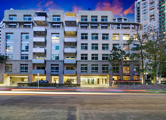A modern apartment building with cars passing by on the street.at Wilshire Margot, Los Angeles, CA