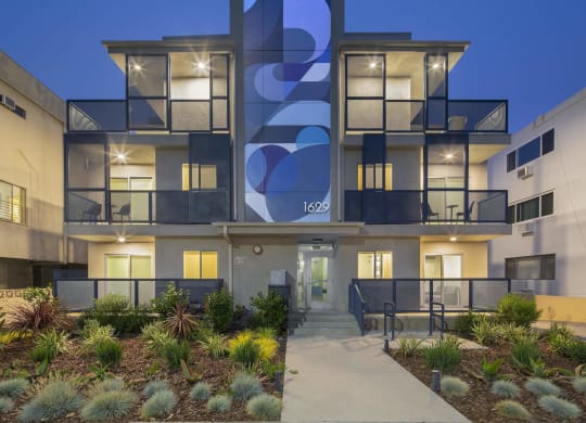 the facade of a modern apartment building with a walkway