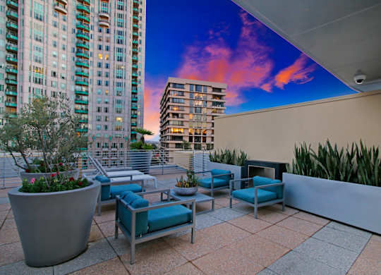 A patio with a couch and a table with a potted plant on it.at Wilshire Margot, Los Angeles, 90024