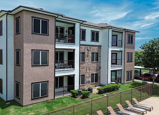 Apartment building with a green lawn in front.