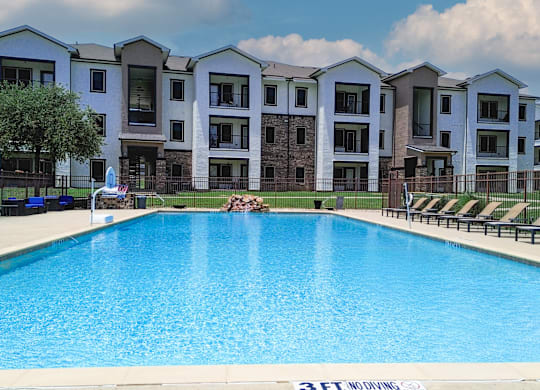 A swimming pool in front of apartment buildings.
