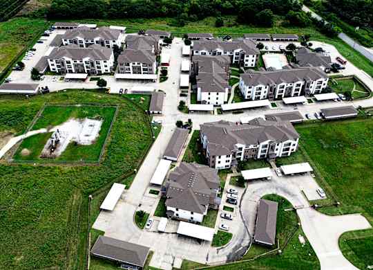 A bird's eye view of a housing development with multiple houses and a central courtyard.