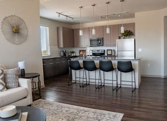 a kitchen with a large center island next to a living room