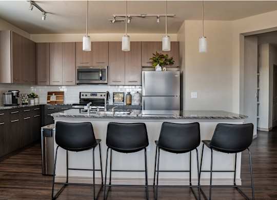 a kitchen with a large island with four chairs around it
