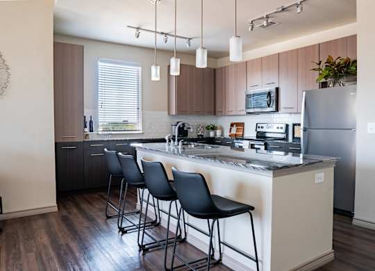 a kitchen with a large center island with a breakfast bar