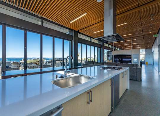 a large kitchen with a sink and a view of the ocean