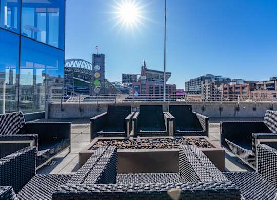views of the city skyline from the roof of a building with lounge chairs