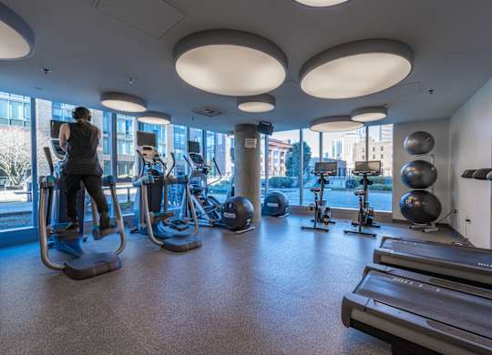 a woman exercising in a gym with cardio equipment