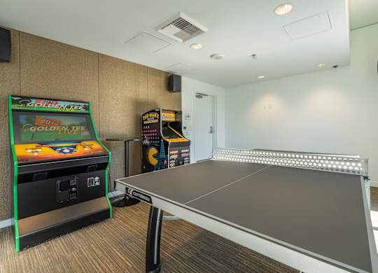 a game room with a ping pong table and a video game