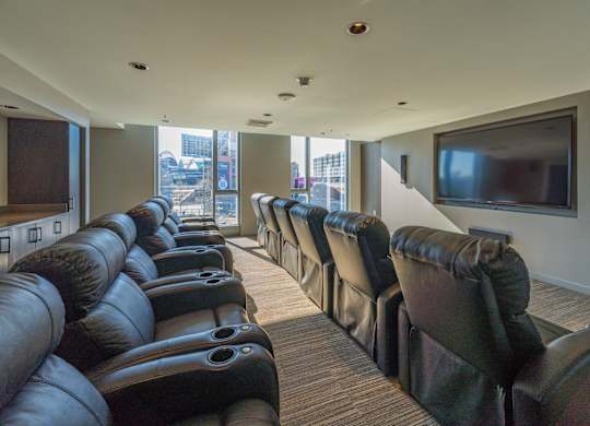 a large screening room with leather chairs and a television