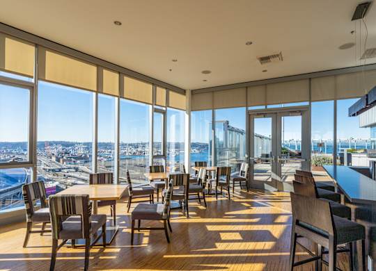 a restaurant with tables and chairs and a view of the city
