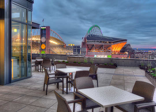 a terrace with tables and chairs and a view of a stadium