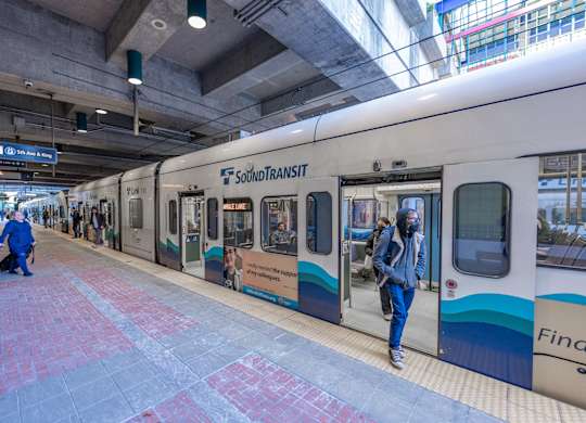 a subway train at a station with doors open and passengers exiting