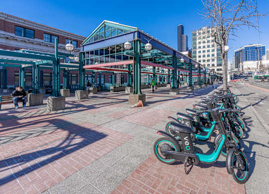 a row of bikes parked on a sidewalk in front of a building